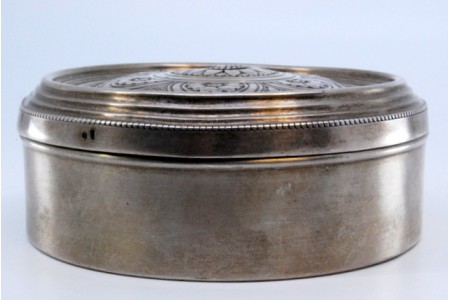 Guarda joias em prata de forma circular com motivos florais gravados na tampa basculante.